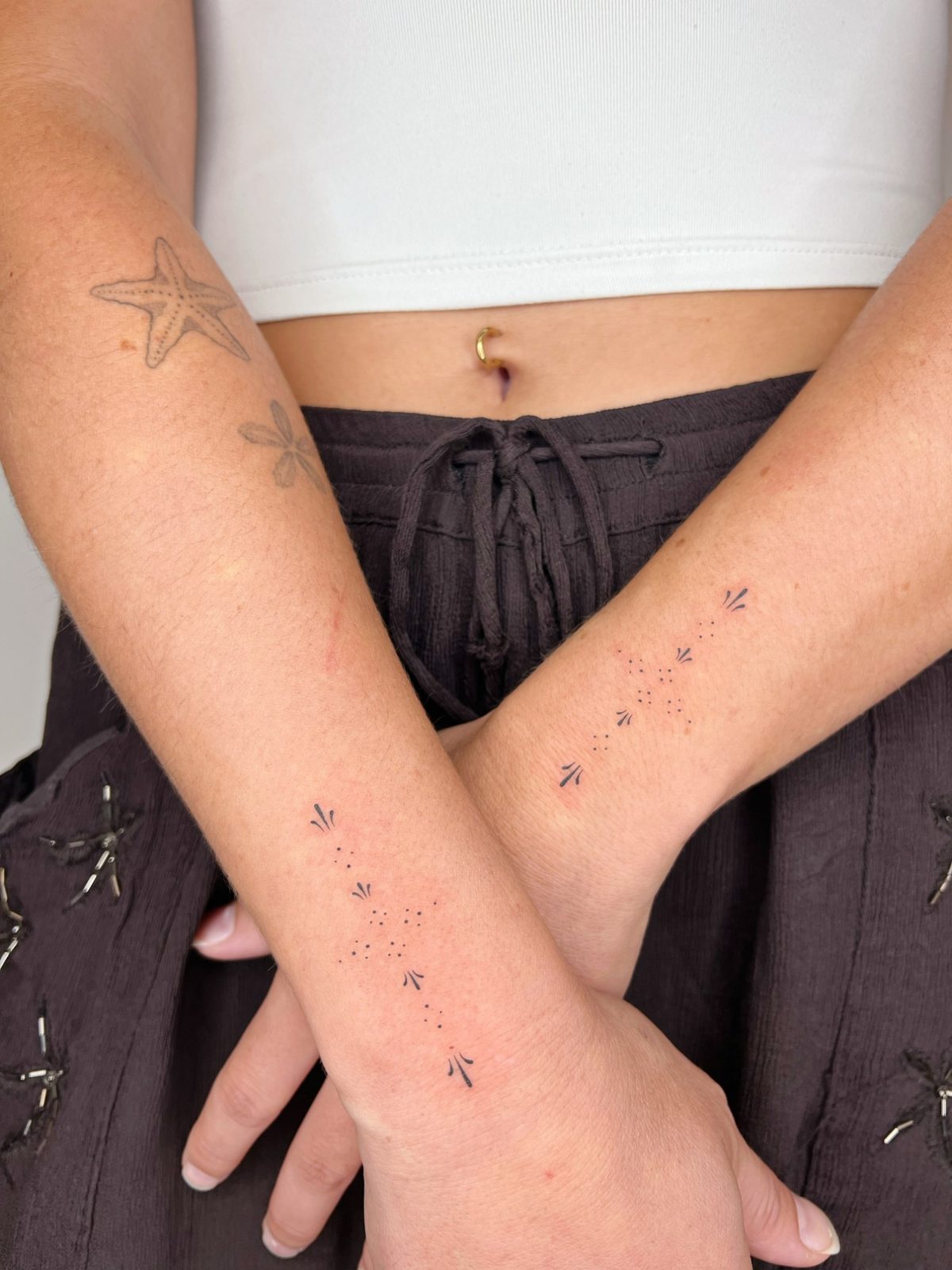 Tatouage matching ornemental en points et petits motifs sur deux avant-bras